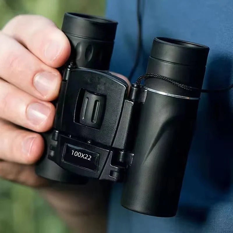 Hand holding mini binoculars showing lens coating